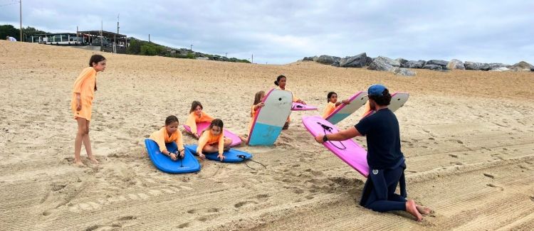 Supernova colonie de vacances gym gymnastique fille réalisant une figure sur barre assymétrique