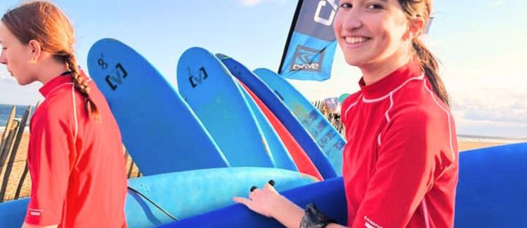 Supernova colonie de vacances pose en groupe devant un surf sur la plage du pays basque