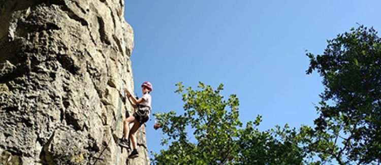 Supernova camp de vacances ado qui escalade une paroi naturelle enardèche