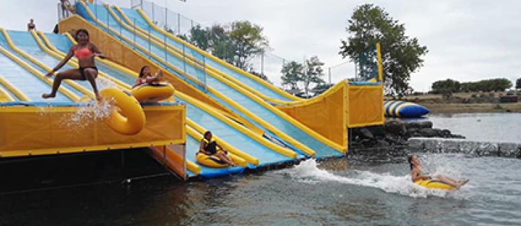 Supernova colonie de vacances été ados faisant du toboggan gonflable au parc aquatique