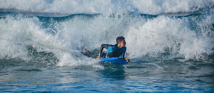 Supernova colonie de vacances adolescent qui fait du surf sur l'océan